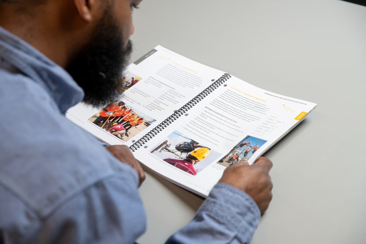 Man looking at NLC curriculum while seated at a desk | Northwest Lineman College